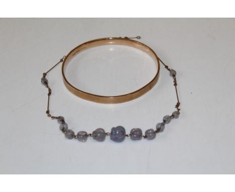 A 9ct metal core bangle, internal diameter of 8cm. Gross weight approximately 31.54 grams. Along with an early 20th century g