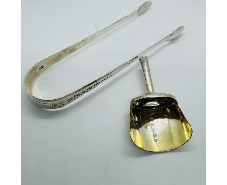 George III tea silver comprising a shovel caddy spoon along with a set of sugar tongs. The caddy spoon, with gilded bowl, mar