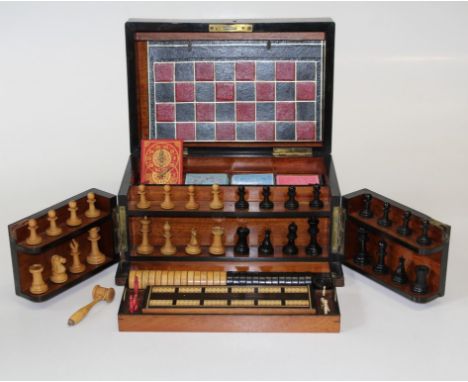 A late Victorian/ Edwardian walnut games compendium. The hinged top and front revealing a well fitted interior, including Wil