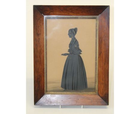 19th century English School, a full length silhouette portrait of a lady holding a letter. Cut card and ink, heightened with 