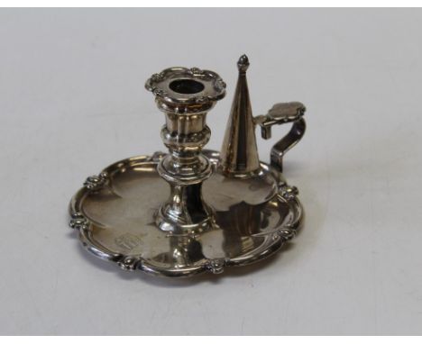 A William IV silver chamberstick, the circular pan centred by a short nozzle and sconce, having an attached snuffer, armoral,