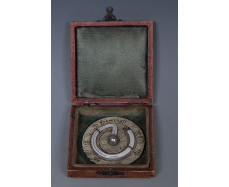 A 19th century French travelling thermometer, coiled mercury tube, Farenheit scale, 5cm diam, associated case  