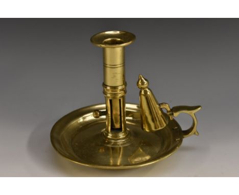 An 18th century silver shape brass ejector chamber stick, flared sconce, scroll-capped handle, dished base, conical snuffer, 