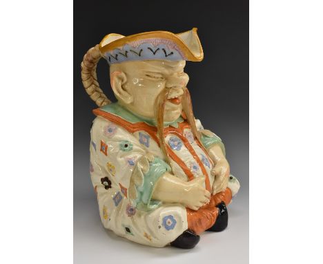 A large 19th century Continental pottery chinoiserie toby jug, as a rotund Mandarin, seated, wearing a brightly decorated rob