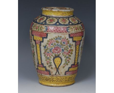 A Persian tin glazed ovoid vase. brightly decorated in the 'famille rose' palette with flowering urns within architectural ni