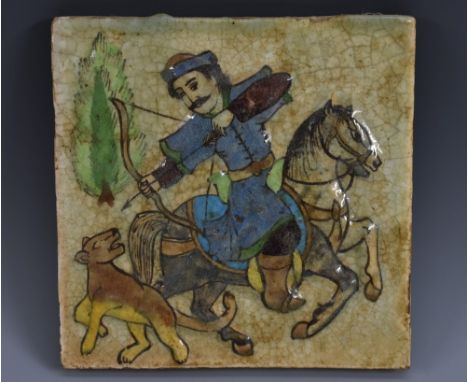 A Qajar fritware square tile, the centre moulded in high relief and and decorated in underglaze, coloured pigments with a hor