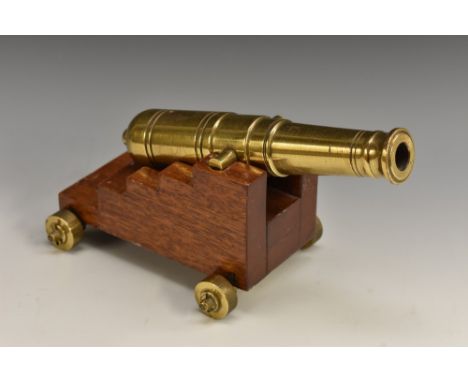 An early 20th century bronze desk top signalling cannon, open touch-hole, mahogany stepped carriage, 23cm long