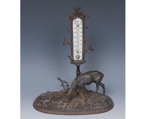 A late 19th century cast and painted desk thermometer, as a stag grazing beside a tree, 26cm high, c. 1890 