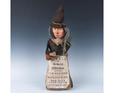 Vintage and unusual figure of a woman from New England who is wearing an apron of a flyer that reads Tryals of Seberal Witche