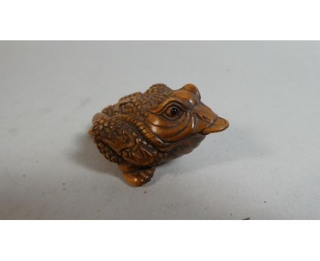 A Oriental Netsuke in the form of a Three Legged Toad with Coin in Mouth, Signed to Base 