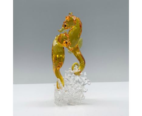 Sculpture featuring two finely faceted amber crystal seahorses gracefully intertwined. The clear crystal base mimics ocean wa