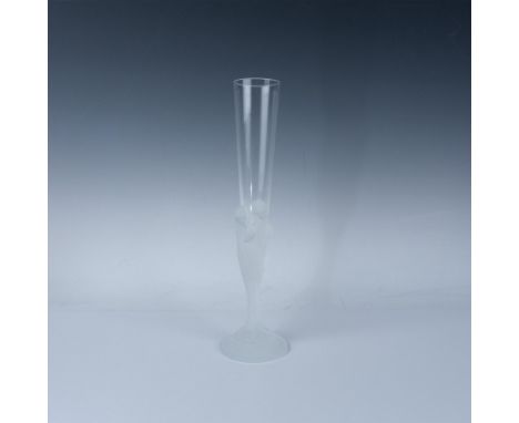 A clear glass with a frosted stem featuring the faces of seven women intertwined and flowing to the base. Erte engraved at ba
