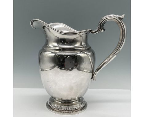 Footed silver pitcher with embossed rope design and leaf handle with wide spout. Rogers Sterling engraved mark. 618 g. Issued