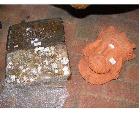 A terracotta garden wall plaque in the form of King Arthur, together with a box of crystal decanter stoppers 