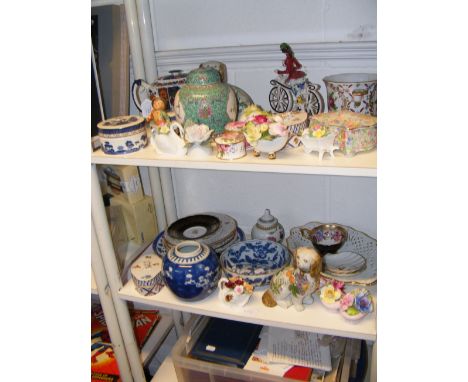 Two shelves of collectable ceramics including Hummel figure