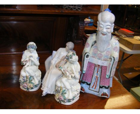 A Danish ceramic figurine of violin player, together with a pair of antique porcelain figurines and a ceramic Oriental deity 