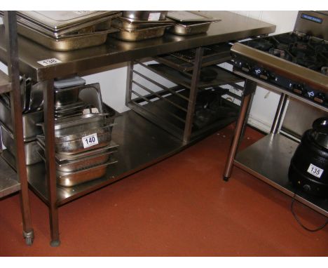 A two tier stainless steel preparation table with storage shelves and pot shelf under