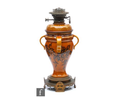 A 19th Century Linthorpe oil lamp, the shape 652 body attributed in design to Christopher Dresser, glazed in mustard with a f