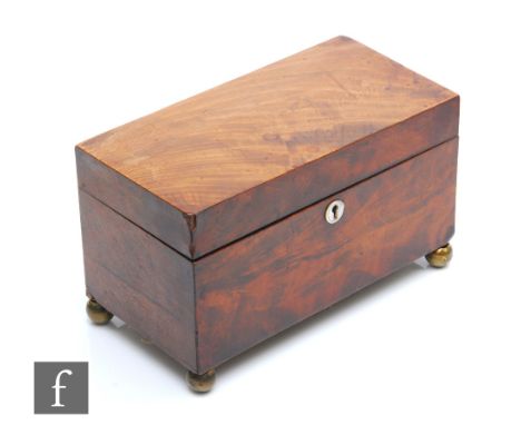 A late Regency period mahogany tea caddy raised to brass ball feet, twin section interior, lacking mixing bowl, retains the k