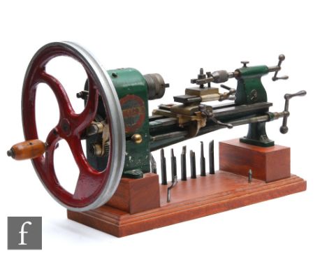 A large Damaco 5 watch makers lathe, green painted, with tools, on a stepped mahogany base, length 63cm. 