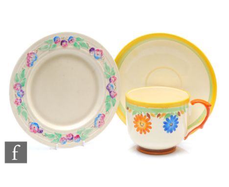 A large 1930s breakfast cup and saucer decorated with hand painted orange and blue flowers within a yellow and green band, al