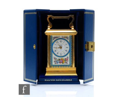 A boxed Halcyon Days Enamel carriage clock decorated with a spray of flowers to the front panel, height 17cm including carry 