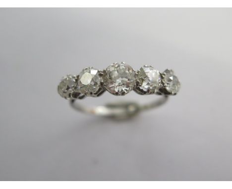 A five stone diamond set half hoop ring, the white shank (possibly platinum) and chenier shoulders to five old cut diamonds i