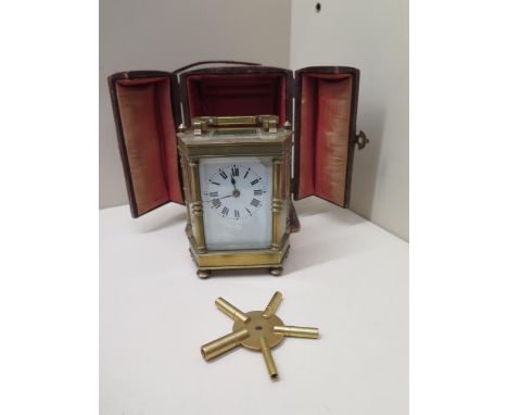 A brass hexagonal carriage clock - Height 12cm with handle down in original case with a spider key - running, minor chipping 