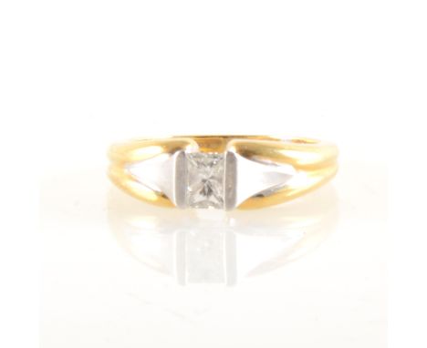 A diamond solitaire ring, the trapeze cut stone claw set in an 18 carat yellow and white gold mount, approximate gross weight