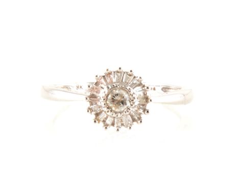 A circular diamond cluster ring, a round brilliant cut diamond milgrain set and surrounded by sixteen baguette cut diamonds c