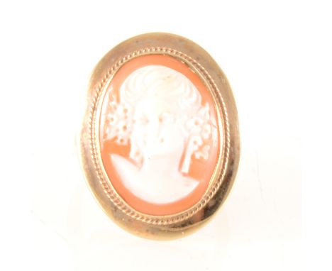 A modern cameo dress ring, the oval carved shell cameo 19mm x 15mm, female profile facing left collet set in a 9 carat yellow