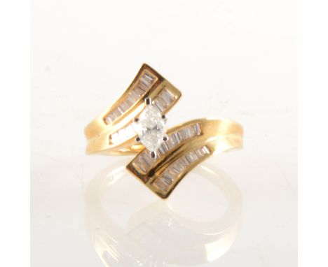 A diamond crossover ring, the central marquise cut diamond claw set in a white metal mount, with eighteen baguette cut diamon
