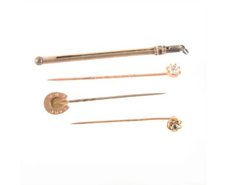 A silver swizzle stick, two yellow metal tie pins stamped 9ct, and another rose metal tie pin.