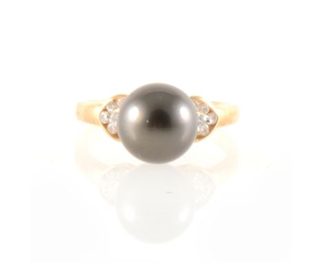 A Tahitian pearl and diamond ring, the 10mm pearl peg set between two shoulders, each set with six small diamonds, in a 14 ca