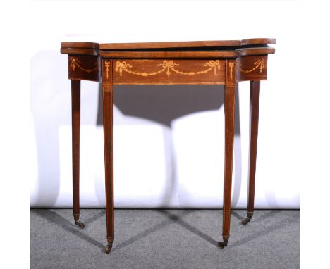 An Edwardian inlaid mahogany card table, foldover top (warped), with inlaid bellflower pendants, satinwood banding, square ta