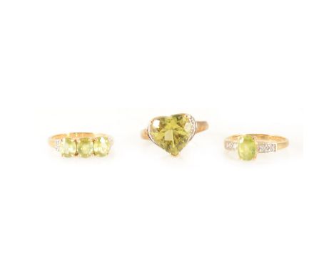 A heart-shaped green stone ring, one round brilliant cut diamond set either side, in an 18 carat yellow mount and shank, an o