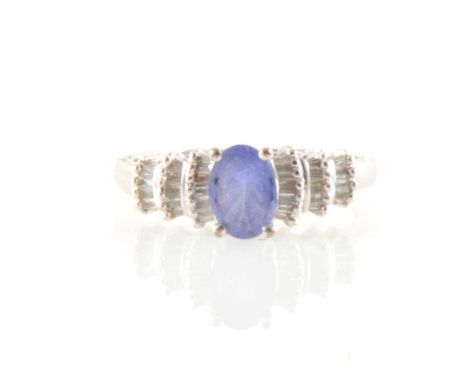 A tanzanite and diamond ring, the oval tanzanite 7mm x 5mm, four claw set with three tiered shoulders, each shoulder set with