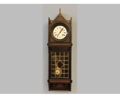 An early 20th century ebonised wall hanging clock, painted in gilt with Egyptian and aesthetic movement sunflowers and motifs