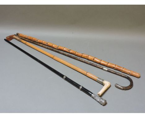 A silver mounted ebony walking cane, two further walking sticks, a hunting crop, and a brief case