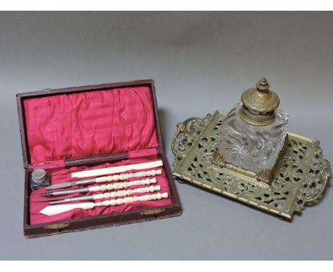 A Victorian writing set, with turned and carved ivory handles, case 20cm wide, and a moulded glass inkwell on a cast brass st