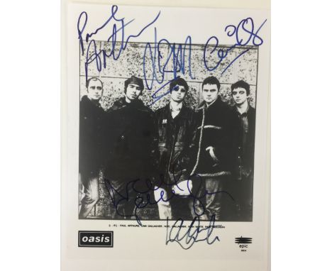 OASIS SIGNED PICTURE - An 8x10" black and white promotional picture of the band signed clearly in marker pen by Paul Arthurs,