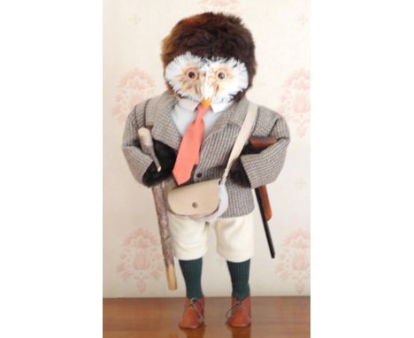 A novelty model, of an owl, in country attire, holding a shotgun and walking stick, 44cm high 