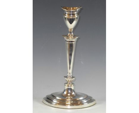 A silver Neo-Classical style candle stick of navette shape, detachable nozzle, vasular sconce, tapered nopped column, stepped