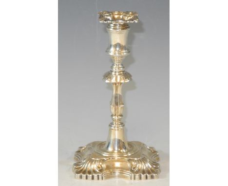 An Edwardian  silver taper stick, in George II style, detachable nozzle, knopped column, shaped square base, with shells to a