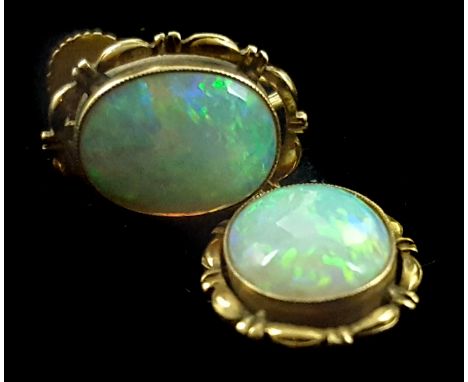 A pair of 1920's harlequin opal and yellow gold single stone earrings, each set to the centre with a single opal displaying a