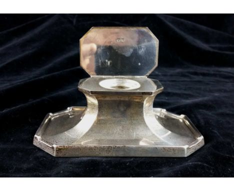 A silver Art Deco Capstan inkwell of canted rectangular form with engine turned border to cover.  the base gallery edge forme