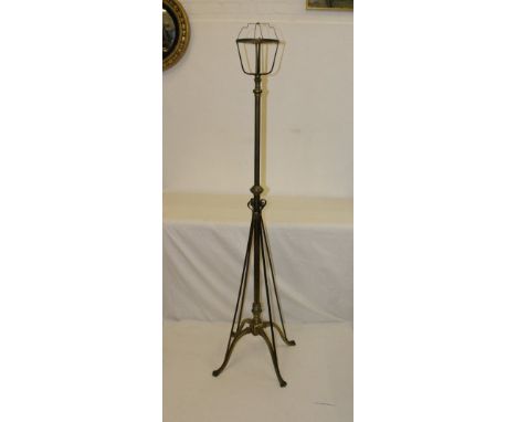 A large brass standard lamp base on 'x' form base with paw feet, copper scrolled railing running from feet to stem, fitted fo