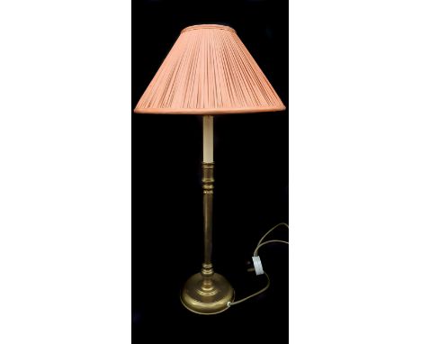 A modern brass candlestick form lamp base, with orange silk shade, 61cm high