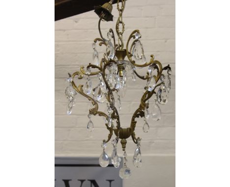 An early 20th C French ormolu Chandelier of foliate c scroll cage form with faceted glass drops, with adjustable hanging chai
