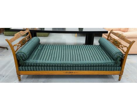 DAYBED, early 20th century painted, with striped green upholstery and bolster cushions, 87cm H x 102cm W x 218cm L.